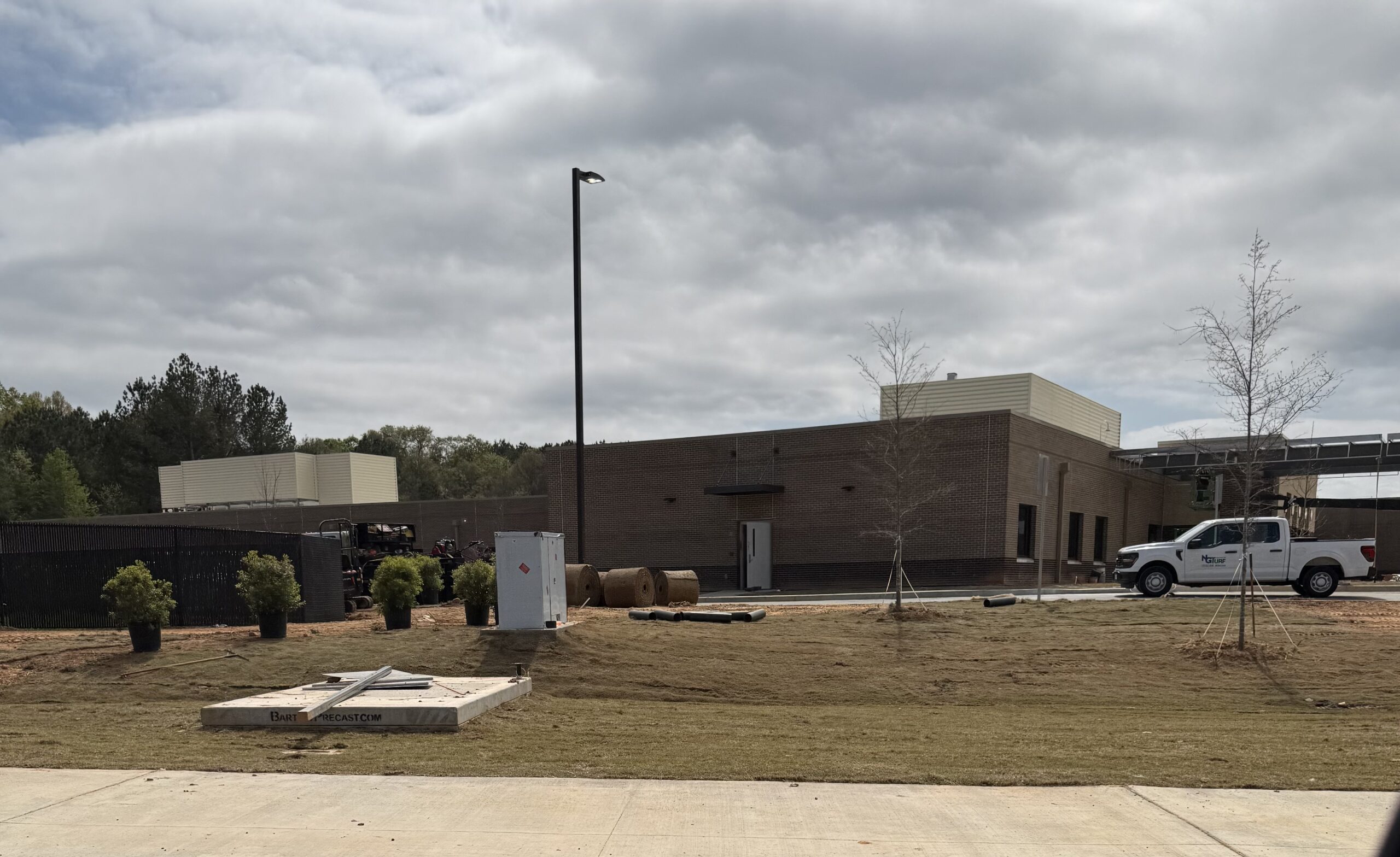 Rear and side view of Piedmont Encompass Health Eastside Rehabilitation Hospital construction site on Loganville Highway — brick exterior, landscaping, and contractor trucks visible, Loganville GA 2026